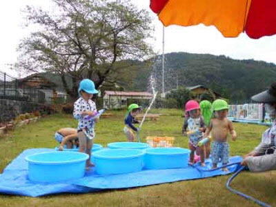 タライと水鉄砲で水遊びをする３歳未満児